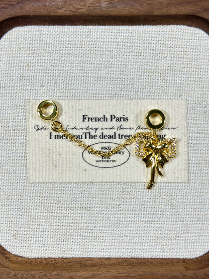 Bright gold bow trickle safety chain